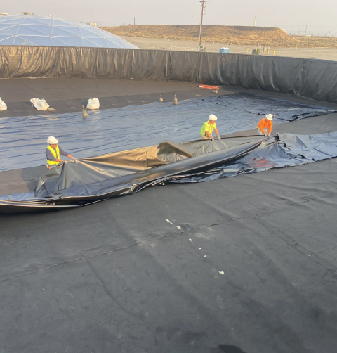 Workers with EM contractor Central Plateau Cleanup Company are installing heavy-duty liners inside two 400,000-gallon leachate tanks at the Integrated Disposal Facility at the Hanford Site. The tanks contain leachate — water from rain, snowmelt, and dust suppression — until it is transferred to an on-site water treatment facility.