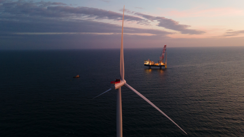 Offshore wind turbines and a boat at sea.