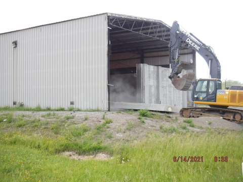 Workers at the West Valley Demonstration Project safely remove a section of a concrete shield wall as part of modifications to a former waste storage facility. A new rollup door will be installed in the opening. This facility will support waste operations during the future demolition of the Main Plant Process Building.