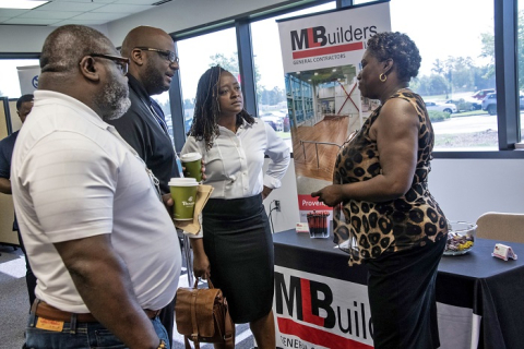 From left, Jonathan, Shawn, and Sharetta McCullough, employees with ML Builders, a Savannah River Nuclear Solutions (SRNS) protégé company, describe their services to SRNS buyer Vera Curtis. This photo was taken prior to the COVID-19 pandemic.
