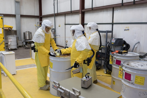 Workers with EM Los Alamos Field Office cleanup contractor Newport News Nuclear BWXT Los Alamos use a new processing line to process and repackage drums of low-level nuclear waste for disposal offsite at Los Alamos National Laboratory’s Technical Area 54.