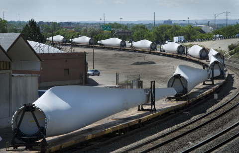 Wind turbine blades wind their way by train through Denver.