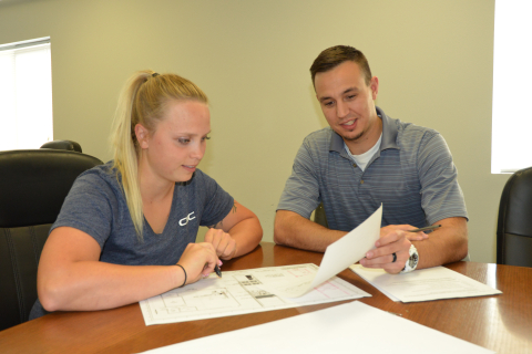 Engineer Joe Cort, right, reviews documents with intern Shari Reese. Cort is one of 14 engineers who began their Hanford careers in the internship program with contractor Hanford Mission Integration Solutions and transitioned to full-time employment after graduation. This photo was taken prior to COVID-19 safety protocols.