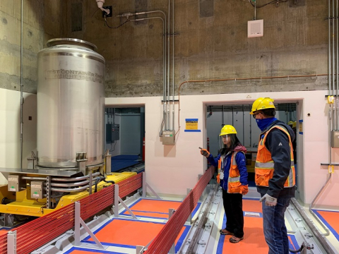 Startup engineer Tanny Doan, left, and Low-Activity Waste (LAW) Completion Manager Scott Miller discuss mechanical equipment testing on the two units that make up the “bogie,” or cart transport rail system.