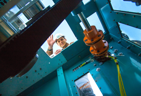 Male worker waves at the camera.