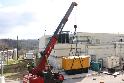 Workers install a backup diesel generator at Building 2026. If there is a loss of power, it can produce enough power to maintain operation of equipment necessary to process uranium-233 at Oak Ridge.