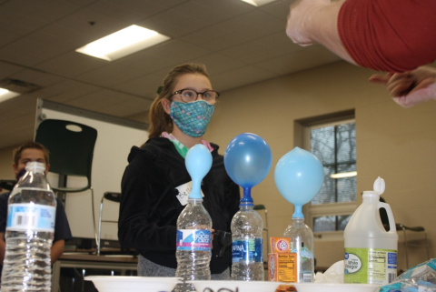 A fifth-grade student listens as Pam Baird of Fluor-BWXT Portsmouth explains a science experiment at Western Elementary School.