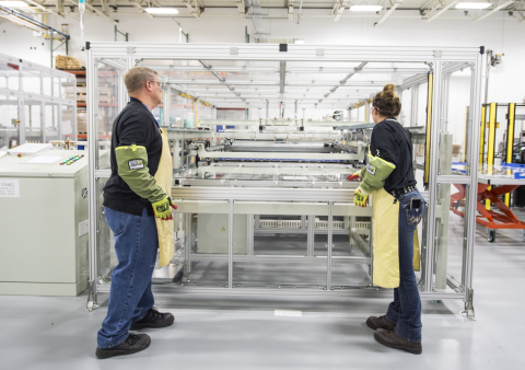 Employees load modules into the edge sealing tool in the Full Module Development Center Lab at the First Solar manufacturing plant in Perrysburg, OH.