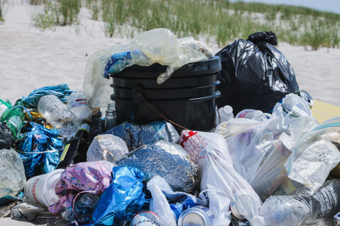 a mound of trash, with plastic bags and bottles.