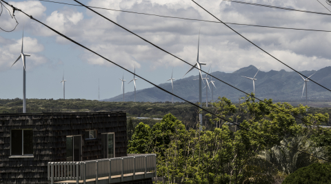 Wind turbines in a city and mountains. 