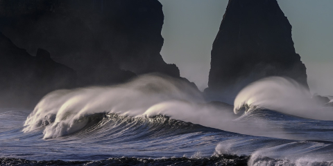 Ocean waves crash against rocks.