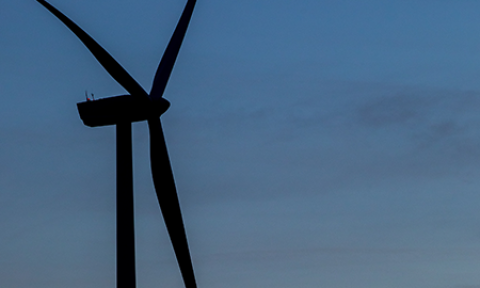 Silhouette of a wind turbine against the sky.