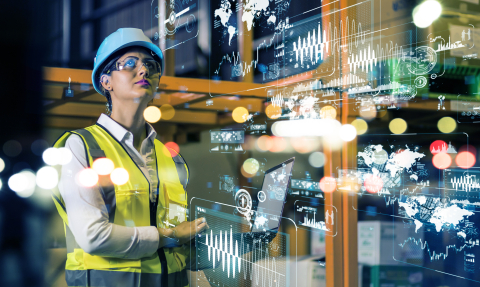 A person in a futuristic display surrounded by graphs and maps