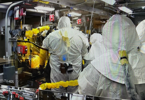 Workers with tank operations contractor Washington River Protection Solutions connect hoses to an ion exchange column inside the Tank-Side Cesium Removal System’s process enclosure before processing another batch of tank waste at the Hanford Site.