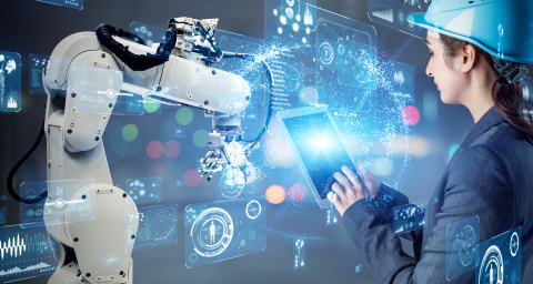 An image of a woker on a tablet next to a robotic arm