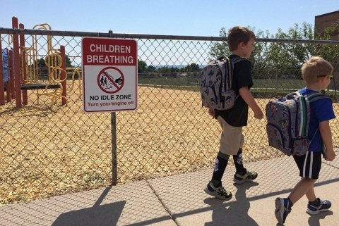 Students walking past a no idling sign