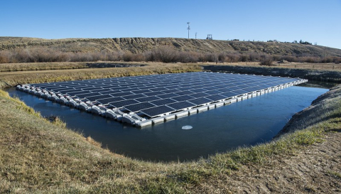 a photo of solar panels over a small pond.