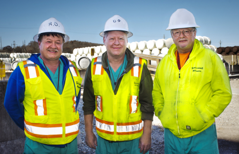 From left, uranium material handler operators Rick, Dave and Randy Osborne gather near one of the X-344 Feed and Withdrawal Facility cylinder yards at the Portsmouth Site.