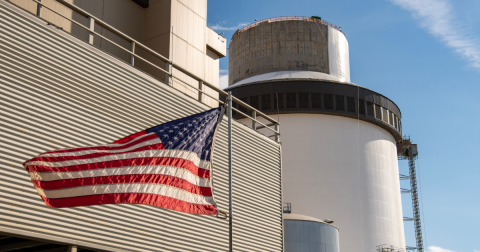 An exterior photo of the Vogtle Unit 4, with an American flag flying in the foreground.