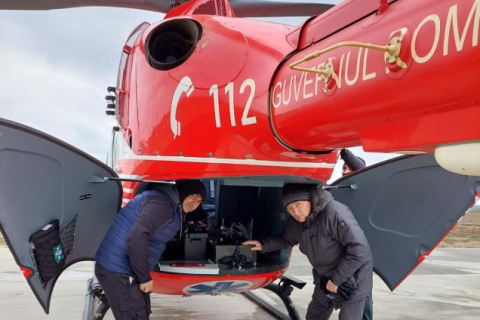 Two NNSA team members emerge from the back of a helicopter.
