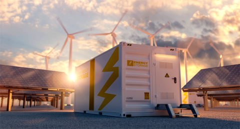 modern battery energy storage system with wind turbines and solar panel power plants in background at sunset