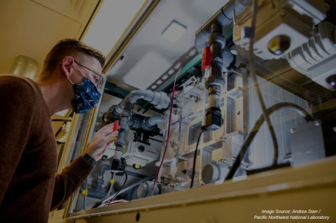 Matthew Fayette looks at a vanadium flow battery in PNNL’s Battery Reliability Laboratory. 