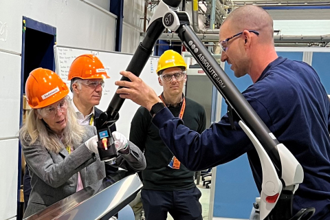 The NNSA Administrator examines a tool used to measure the VVER-440 fuel shroud as a man shows her how it works.