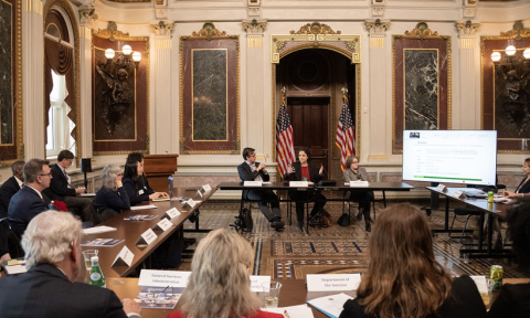 Individuals sitting at tables during a meeting.