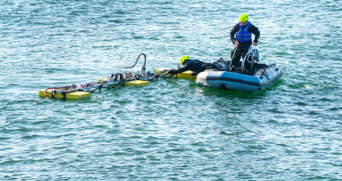 man in boat next to marine energy device