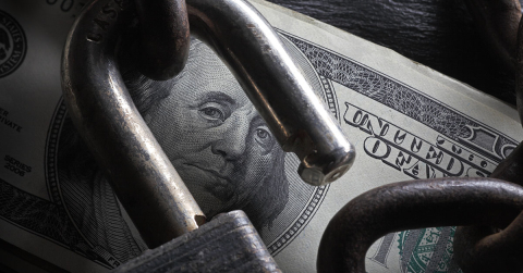 Photo of a dollar and unlocked padlock.
