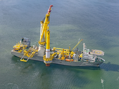 A barge carrying wind turbine equipment in the ocean