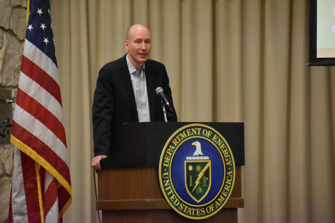 Speaker at podium with DOE seal and US Flag