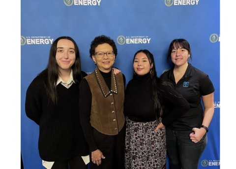 Three interns pose with their mentor.