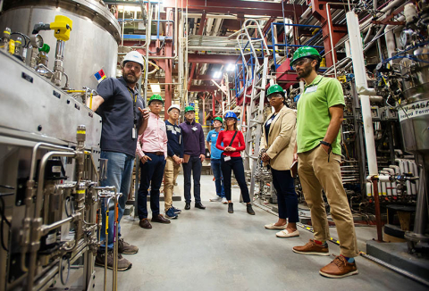 several people wearing hard hats in a manufacturing facility