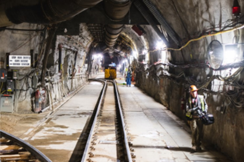 A photo inside a tunnel with rails heading into the distance.