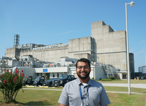 A man stands in front of a large laboratory building