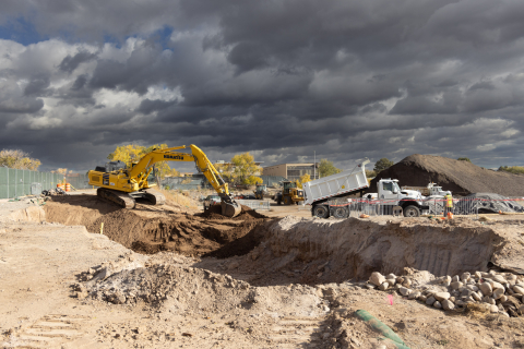 A bulldozer removing debris in a large dirt field