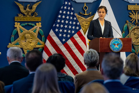 Mary Sotos standing at a podium speaking to an audience.
