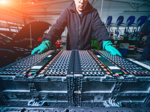 a person standing over a battery array