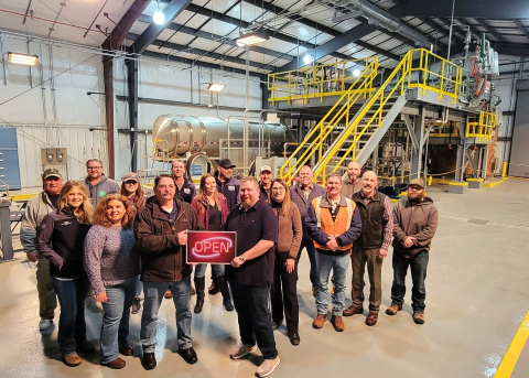 A group of people pose for a picture inside a large facility builidng