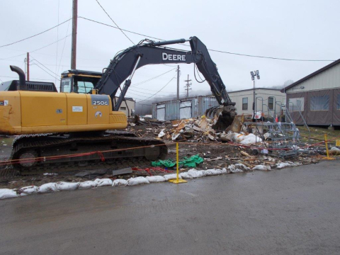 A bulldozer demolishes an old guardhouse