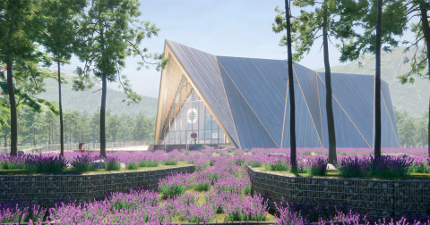 A-frame building sits in field behind purple flowers and small trees.