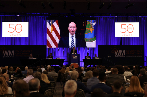 The deputy secretary of the Department of Energy on video on a stage