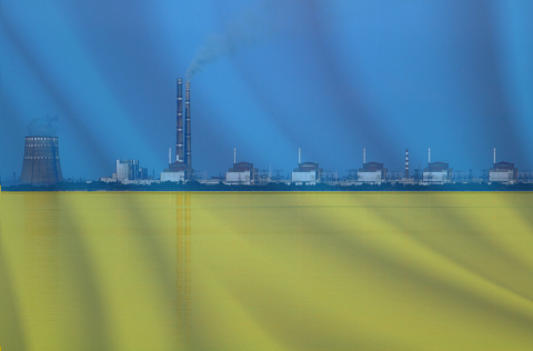 A photo illustration of a Ukrainian flag superimposed over an exterior photo of the Zaporizhzhya Nuclear Power Plant.