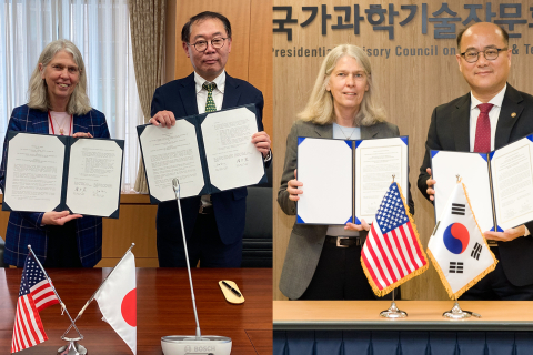 Administrator Hruby holding up a signed agreement with her Japanese and Republic of Korea counterparts.