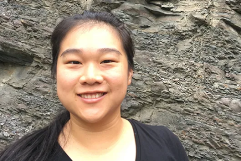 Headshot of Michelle Yuan with large rock wall in background