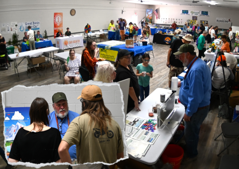 A picture within another picture showing a room with people and a man behind a table showing them something.