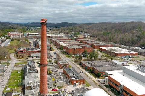 Aerial shot of a work site with a large red cylinder stack in focus