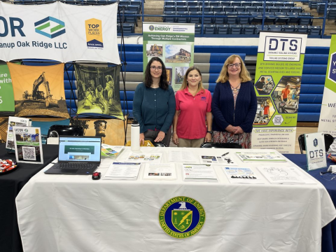 Three women standing behind a table at a career fair day