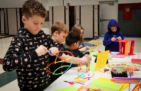 A group of young students work with art materials on STEAM activities